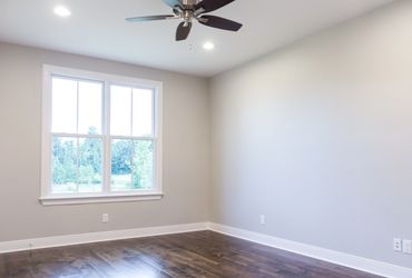A room with white walls and a ceiling fan