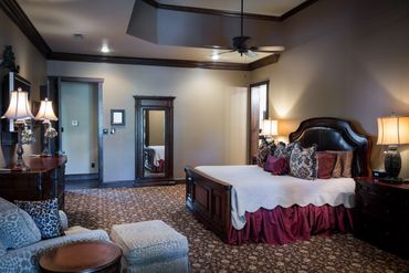 A furnished room with dark wood moldings and beige walls