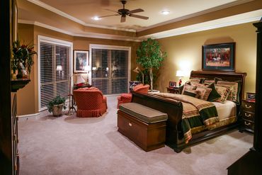 A bedroom with beige, green, and red accents