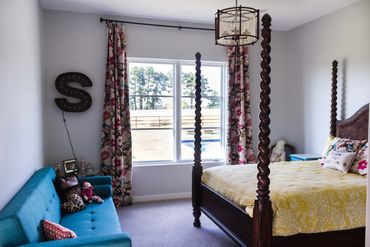 A bedroom with white walls and bright-colored furniture