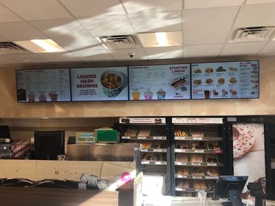 View of a Dunkin' menu board featuring breakfast and sandwich options.
