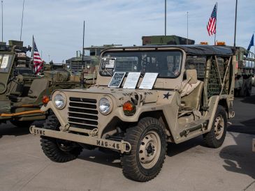 A vintage military jeep with US flags.