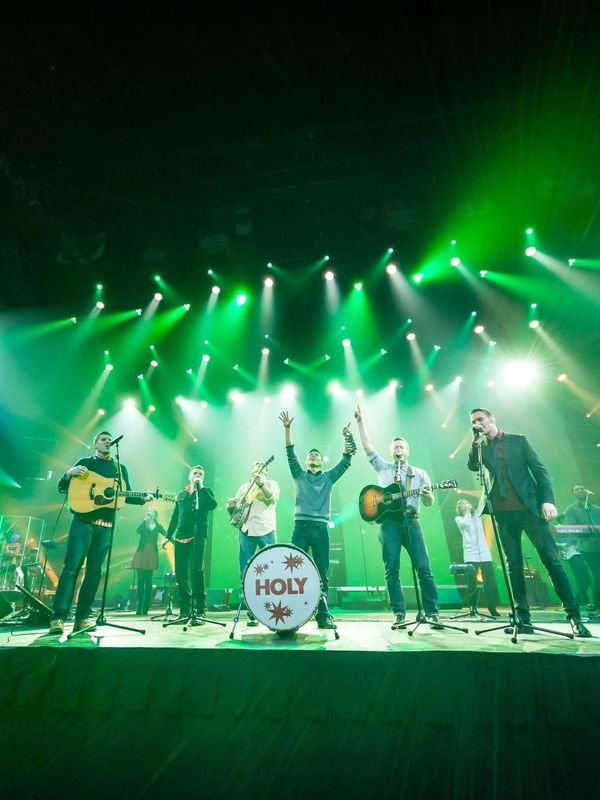 Band performing live on stage with green lights.