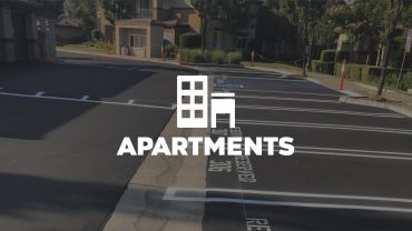 Empty parking lot outside apartment buildings.