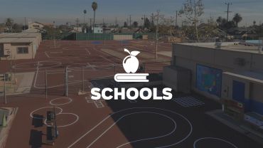 Empty school playground with basketball courts and tracks.