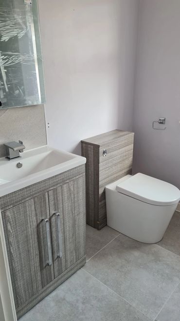 Modern bathroom with wooden vanity and toilet.