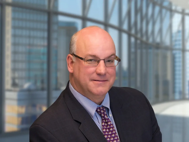 A business man in a large office lobby. 