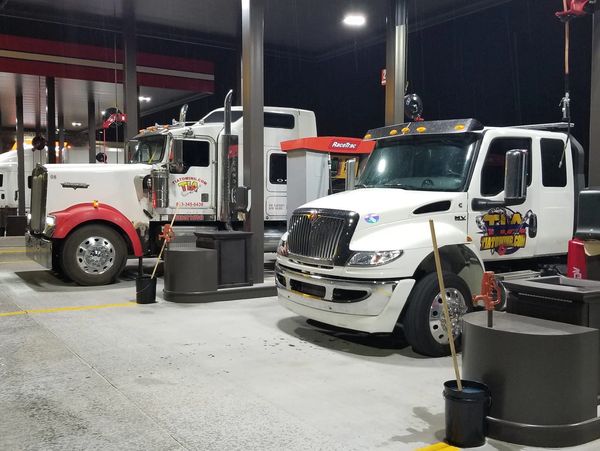 two tow truck in a gas station