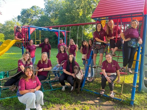 The Aggieland Autism Center team posing on the center's playscape.