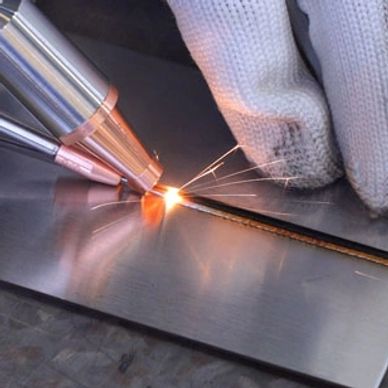 Close-up of metal laser welding with gloved hand.
