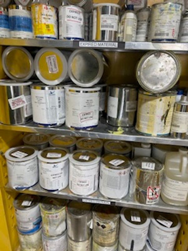 Shelves filled with various paint cans and containers.