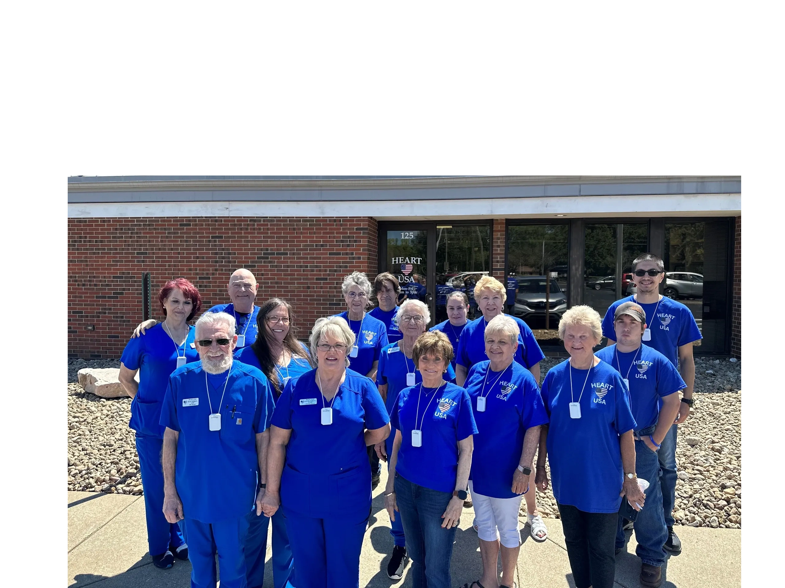 Group of Volunteer staff standing, smiling in front of the Heart USA office.