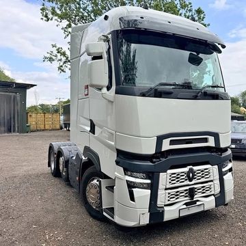 White semi-truck parked outdoors on gravel.
