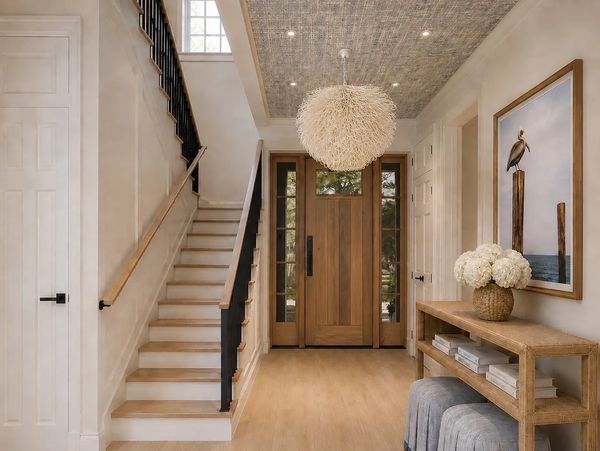 Modern entryway with wooden door and staircase.