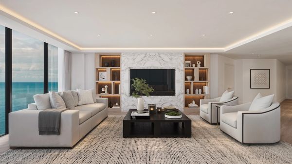Modern living room with ocean view and marble TV wall.