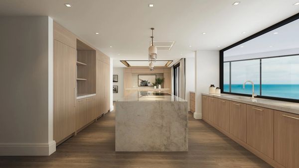 Modern kitchen with marble island and ocean view window.