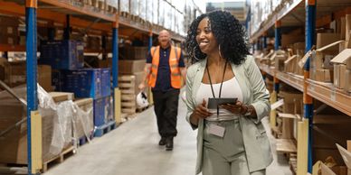 A beautiful black female warehouse manager with workers during the daily duties on site.