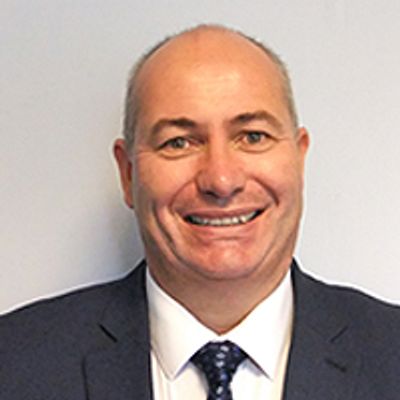Smiling man in a suit and tie posing for a professional headshot.