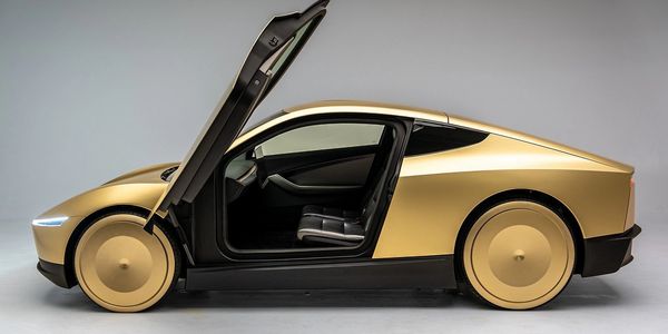 Gold-colored futuristic car with open butterfly door.