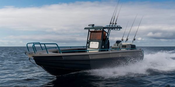 A motorboat speeding on the water with fishing rods mounted.
