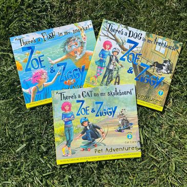 Three children's books from the Zoe &amp; Ziggy series on grass.