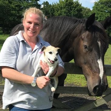 Lady holding a dog next to a horse providing cat sitting and dog walking services in Cheshire.