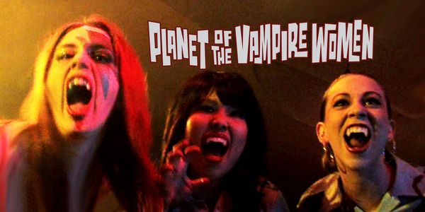 Three women with vampire makeup and fangs.