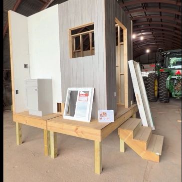 Small wooden structure model with stairs and window frame.