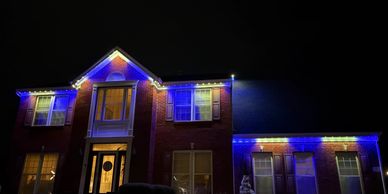 House decorated with blue and white lights at night.