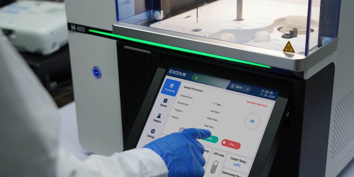 Scientist operating a touchscreen on a high-tech laboratory instrument.