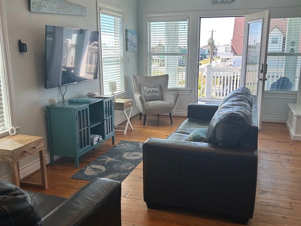 Bright living room with leather sofas and ocean-themed decor.