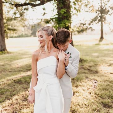 Couple in wedding attire embracing outdoors.