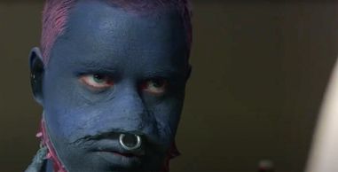 Man with blue face paint and septum ring.
