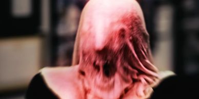 Creepy distorted face covered by a stretched translucent cloth.