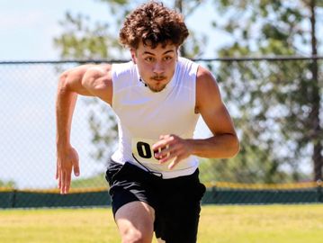Athlete sprinting during outdoor track event with intense focus.