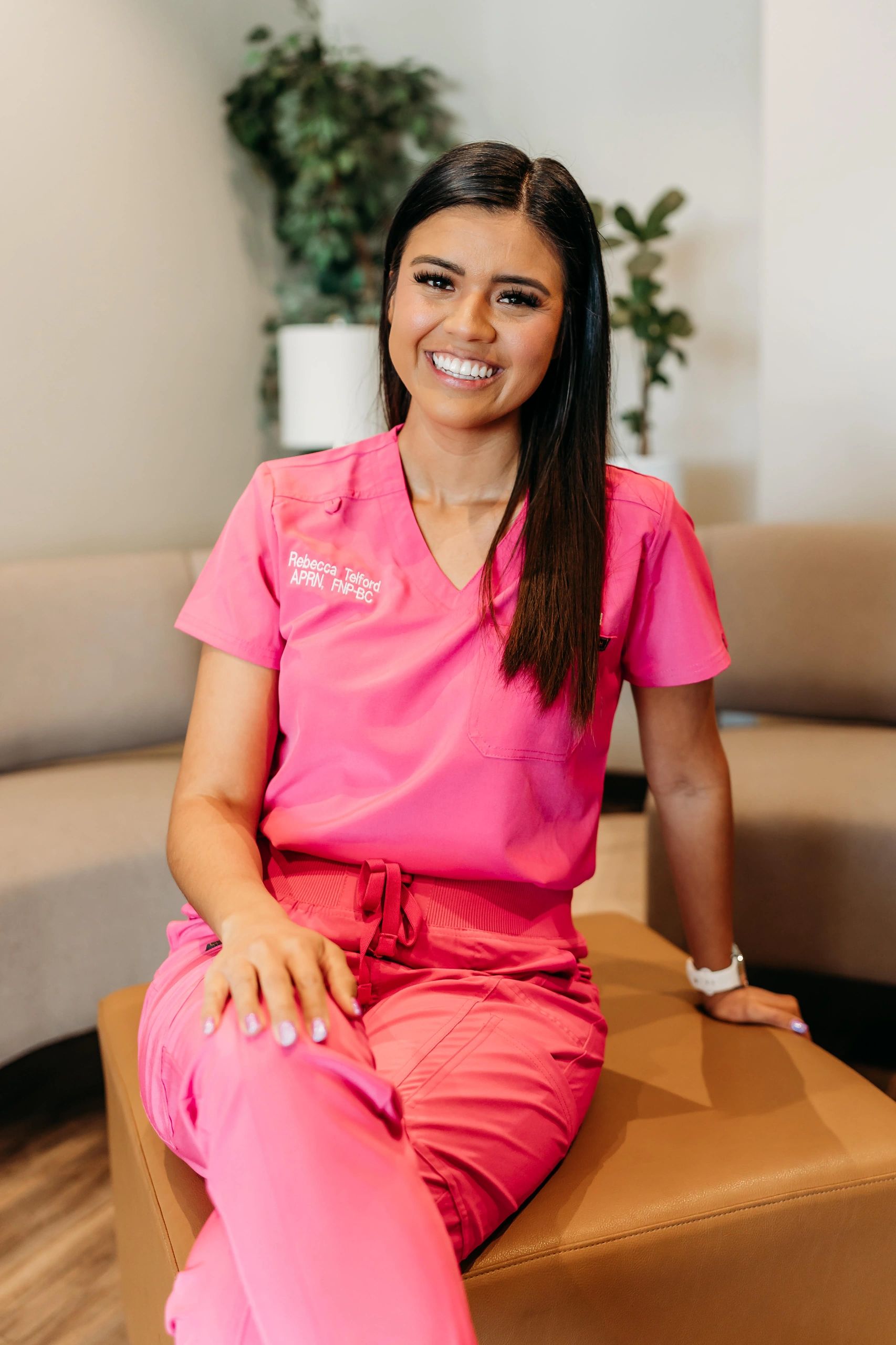 Smiling healthcare professional in pink scrubs.