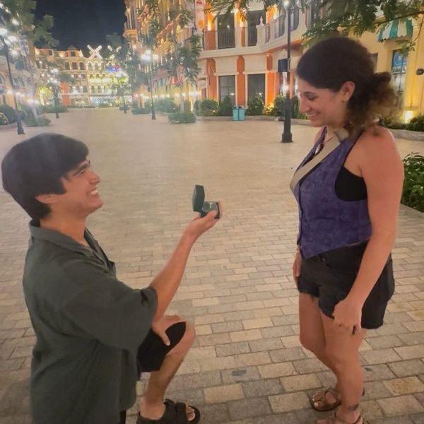 Man proposing to woman on a city street at night.