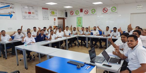 Group of trainees in a classroom giving thumbs up.