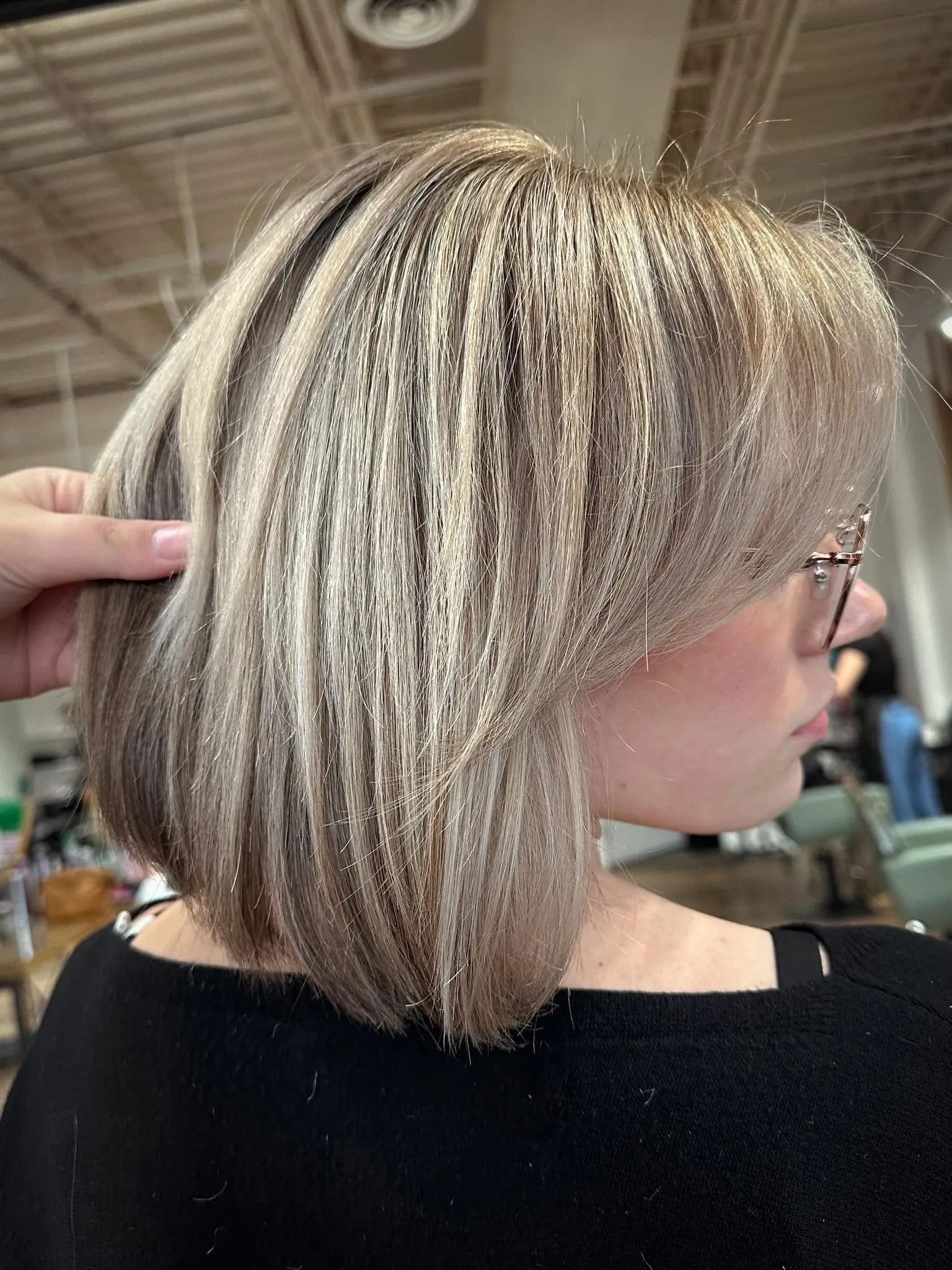 Stack of books next to pencils in a holder and a camera.
