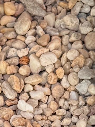 Close-up of various small, rounded pebbles in earthy tones.