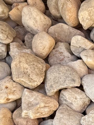 A close-up of many smooth, light-colored stones piled together.
