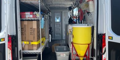 Inside view of a well-organized service van with storage shelves and equipment.