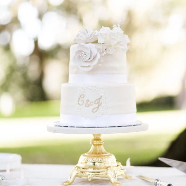 Elegant white two-tier cake with floral decorations.