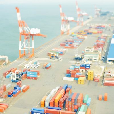 A busy shipping port with colorful containers and cranes along the waterfront.