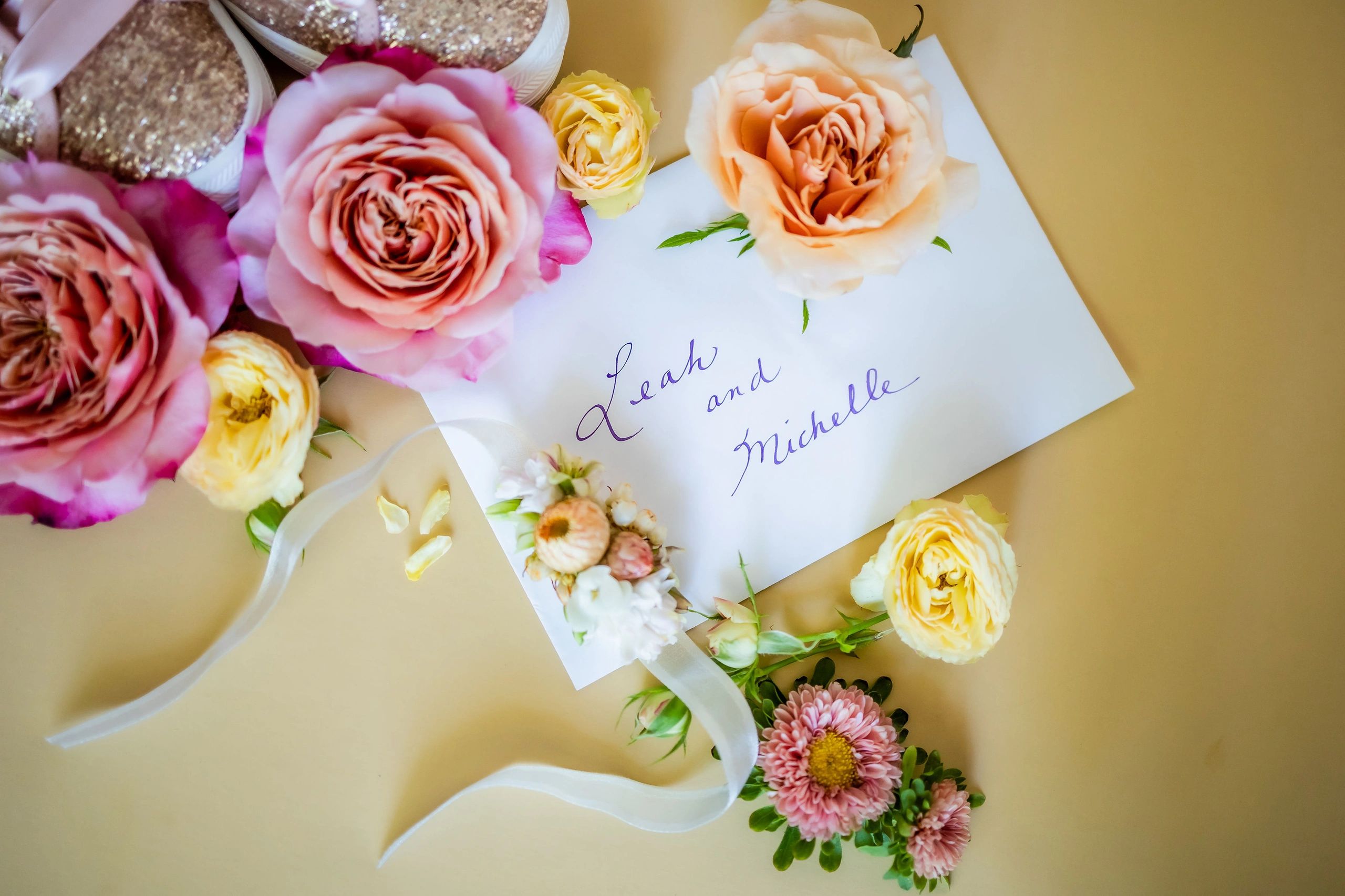 Envelope with names Leah and Michelle surrounded by roses and flowers.
