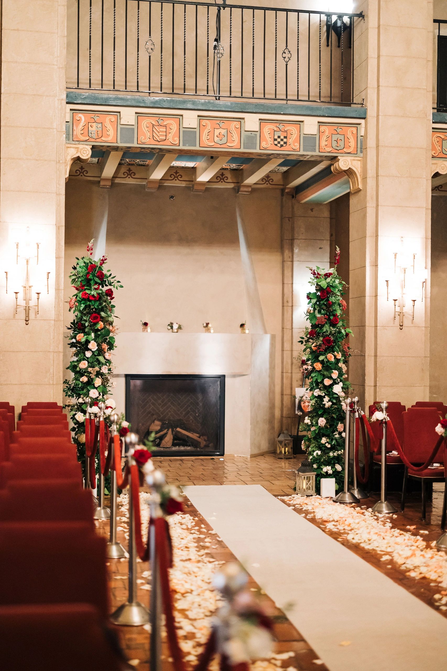 Elegant wedding aisle with floral decorations and rose petals.