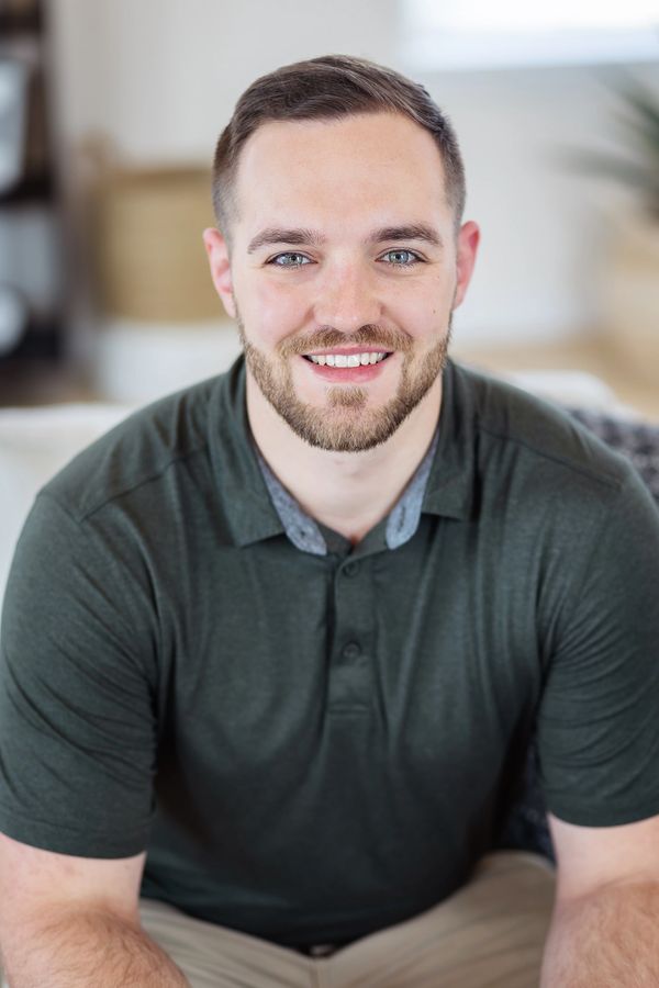 Smiling man with blue eyes and beard indoors.