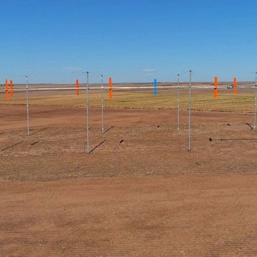 Wind turbines on a barren landscape with clear blue sky.