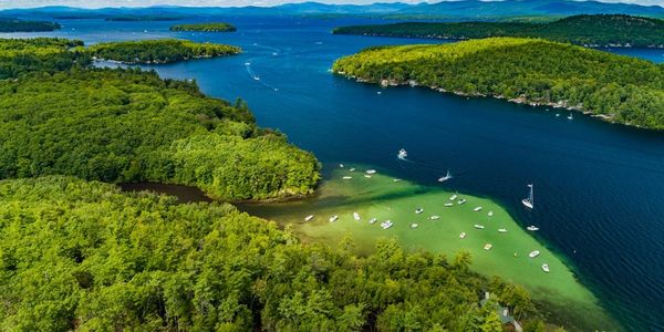 Aerial view of a lake with boats and lush green islands.