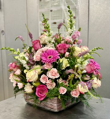 Beautiful table centerpiece with roses, lilies, and stock blooms.